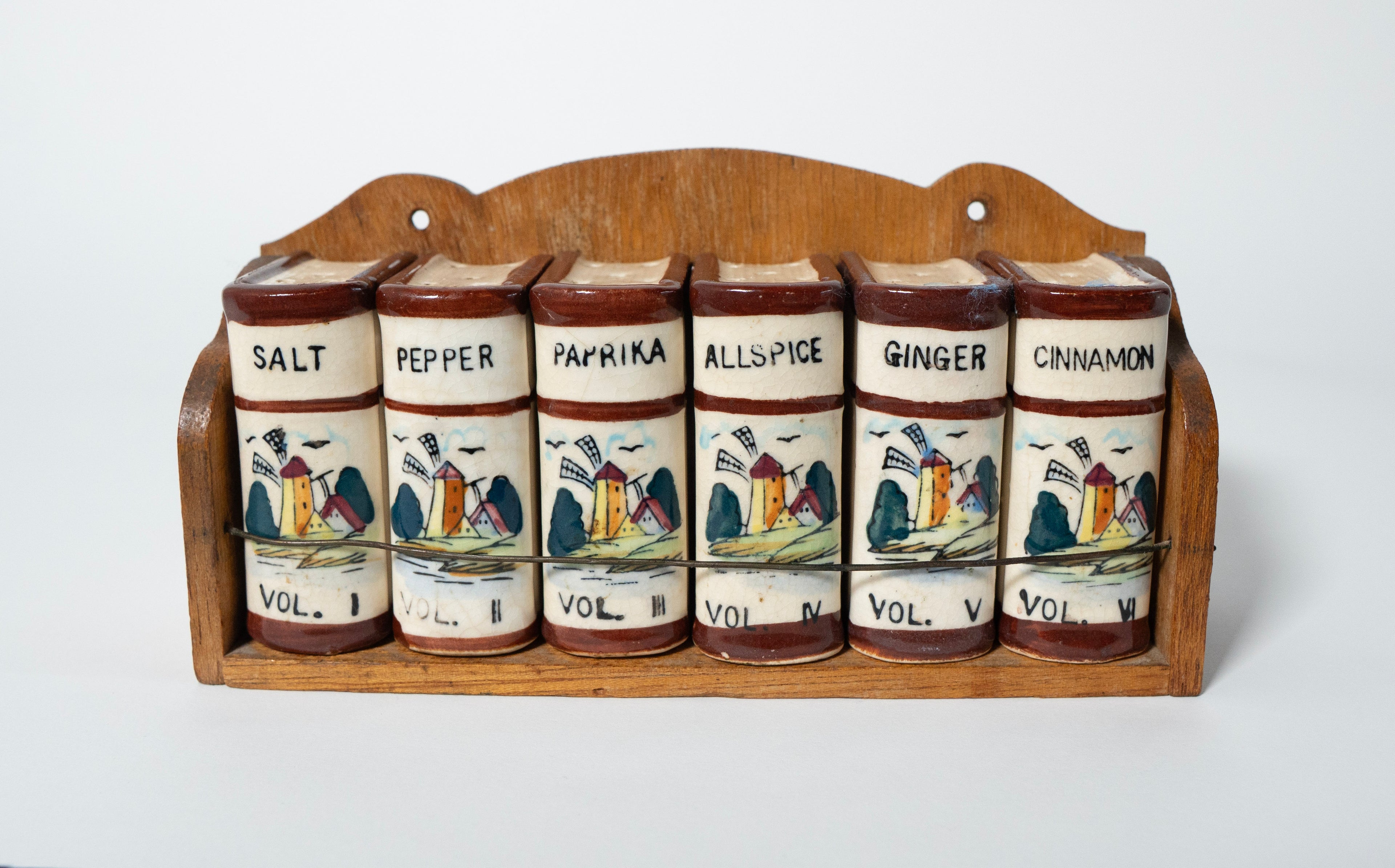 Set of ceramic spice jars with wooden rack on a white background