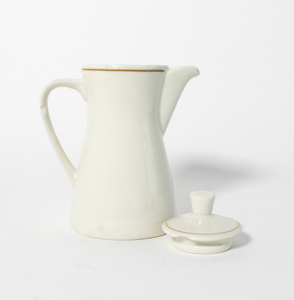 White ceramic pitcher with gold trim on a white background