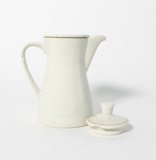 White ceramic pitcher with gold trim on a white background