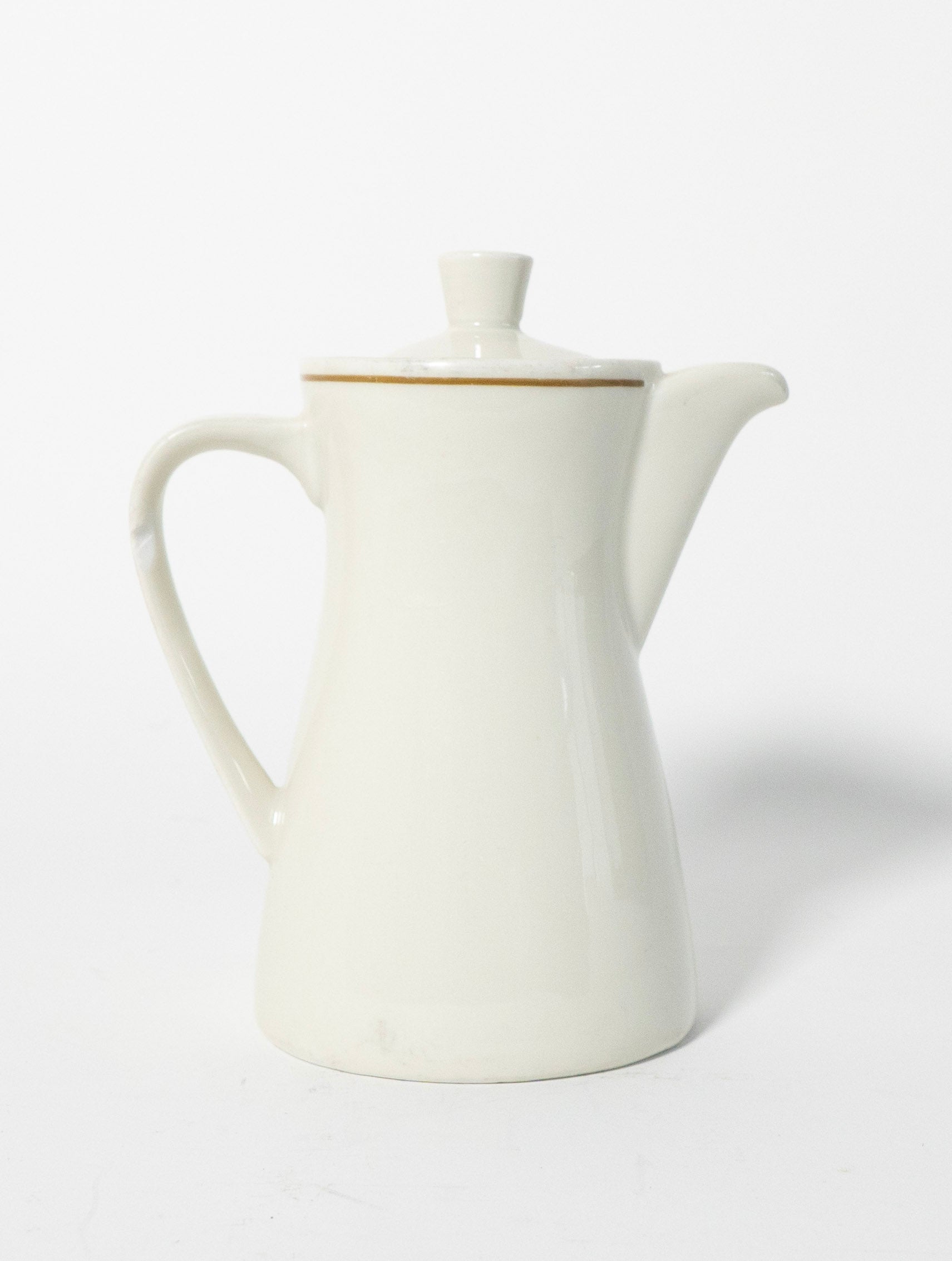 White ceramic teapot with a gold rim on a white background