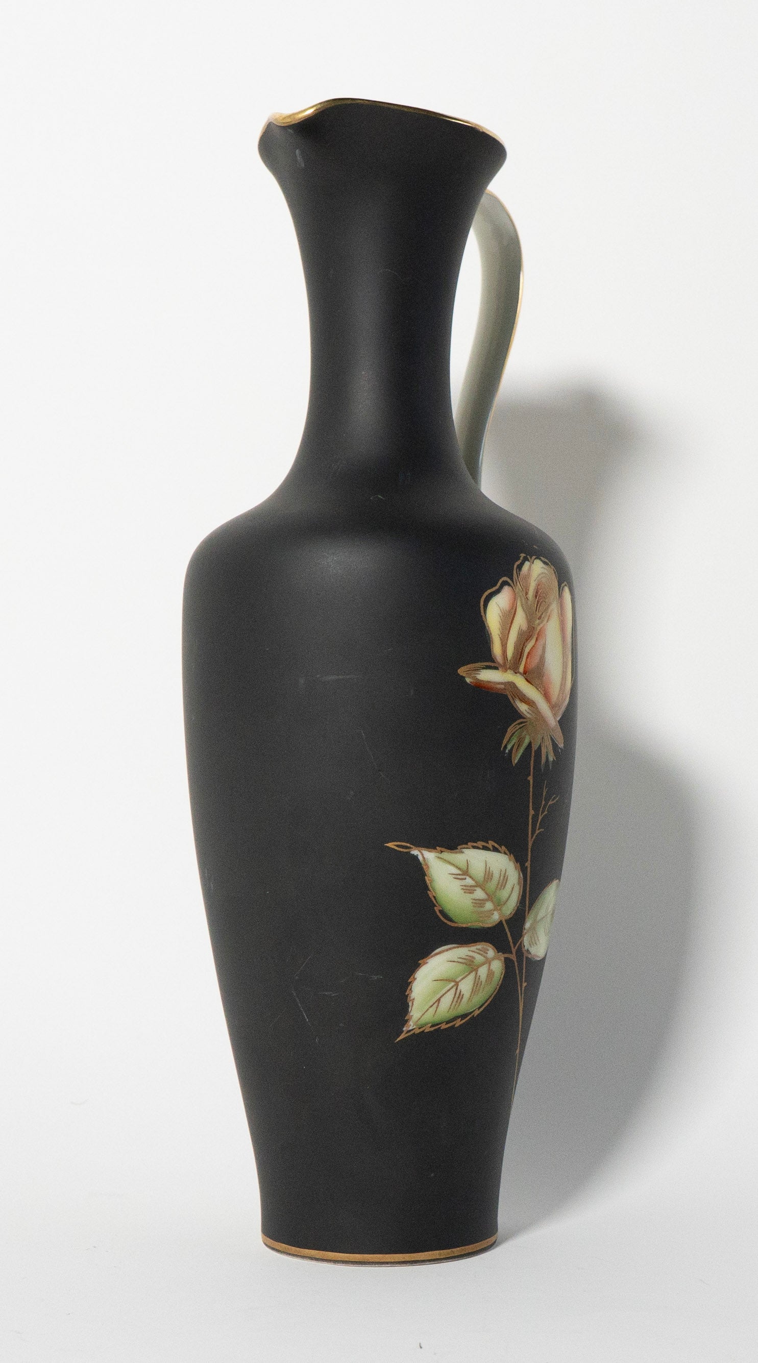 Black vase with floral design on a white background