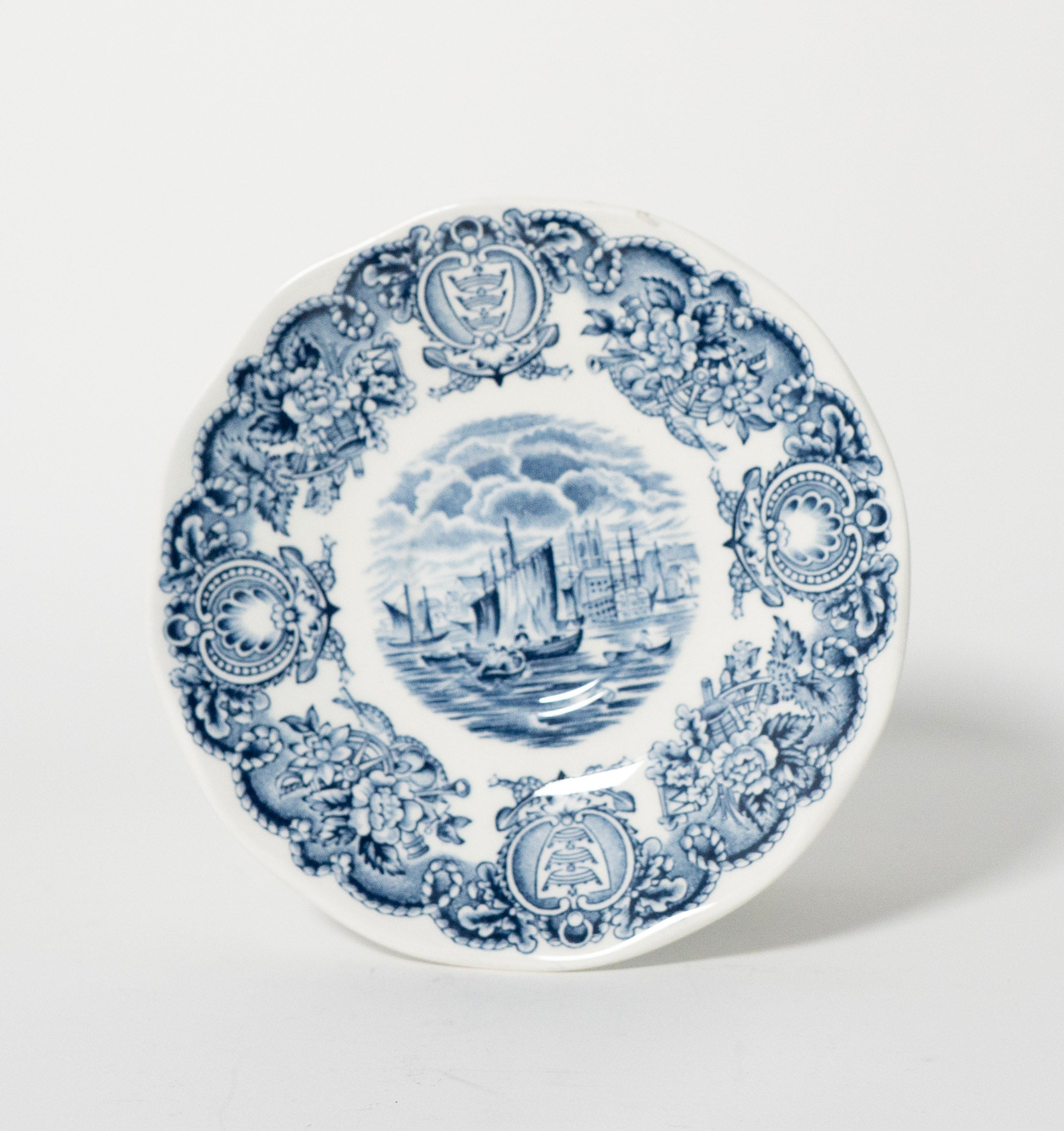Decorative plate with blue and white design on a light gray background