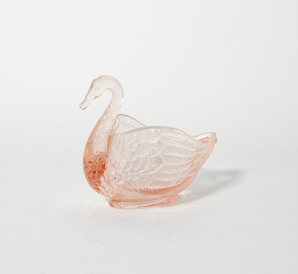 Pink glass swan on a light white background