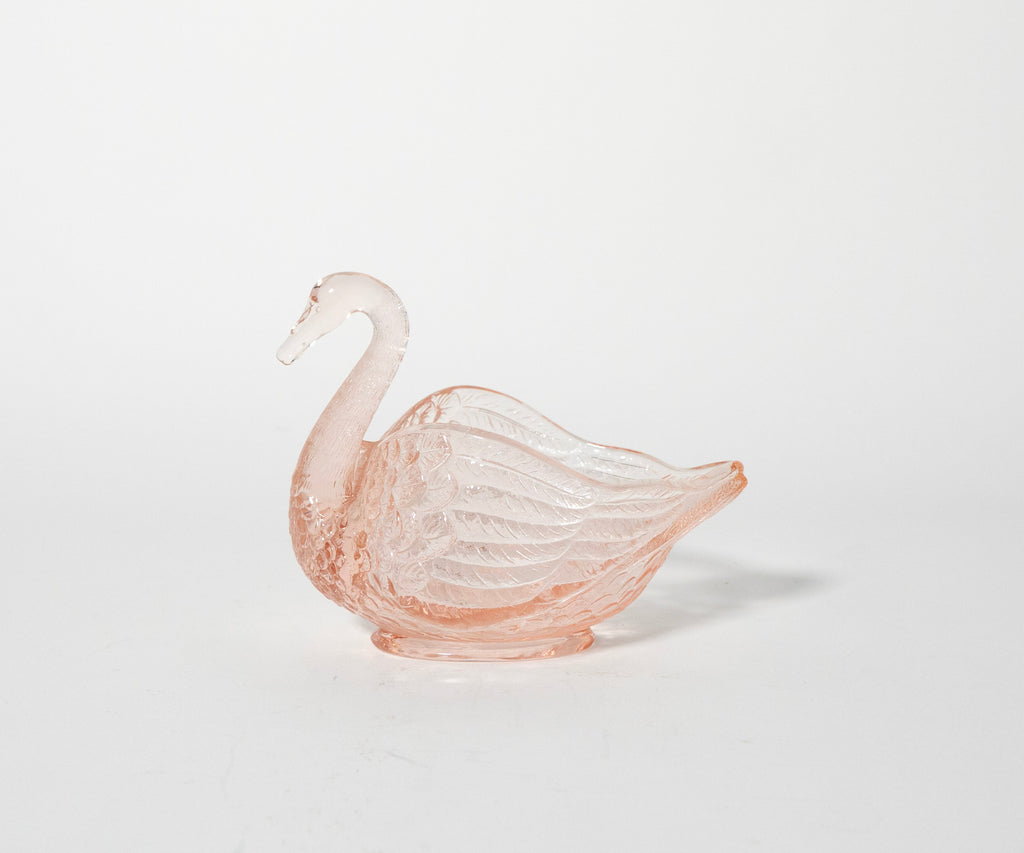 Pink glass swan ornament on a white background