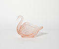 Pink glass swan ornament on a white background