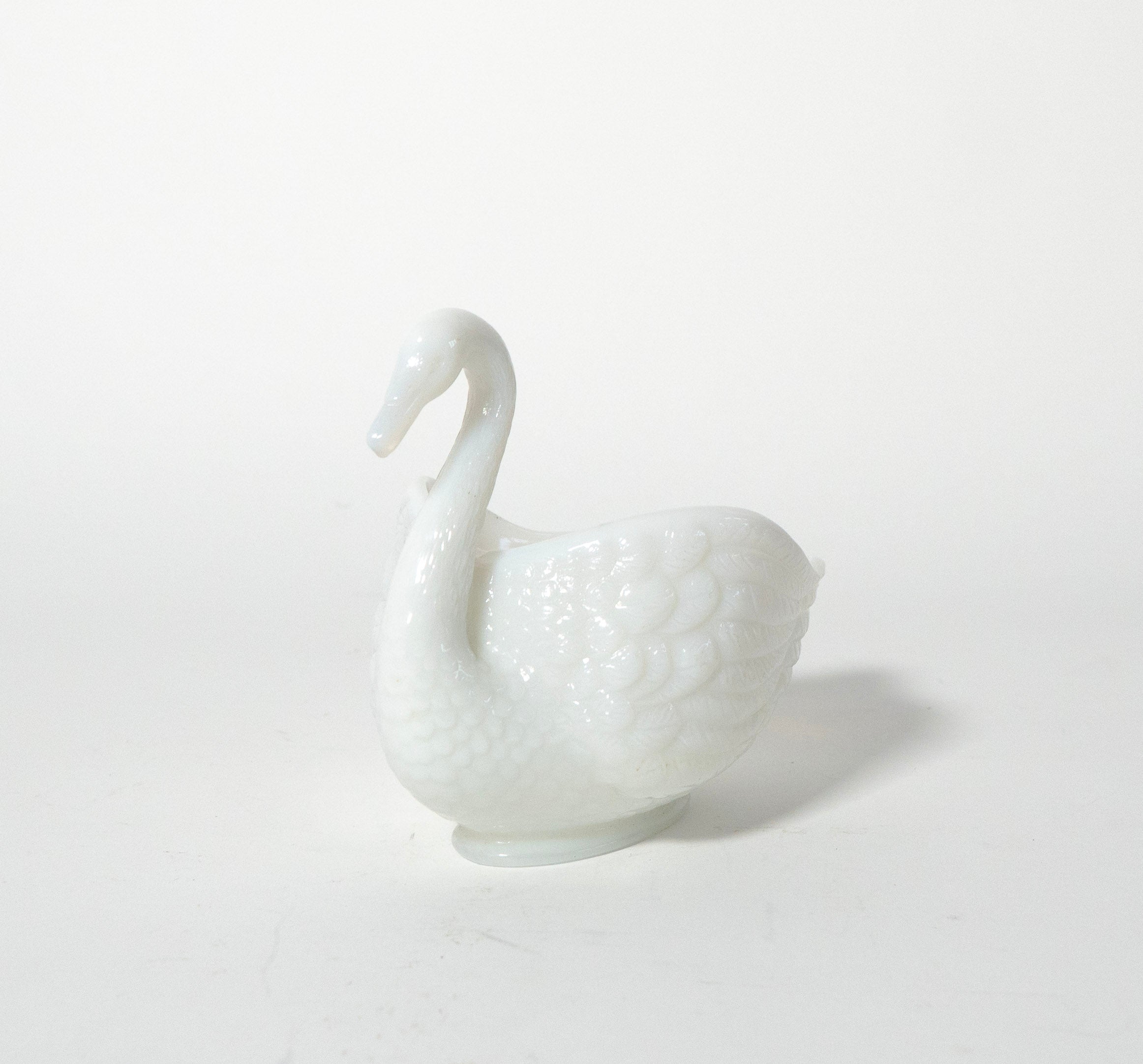 White ceramic swan on a light gray background