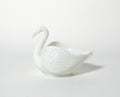 White ceramic swan-shaped object on a light gray background