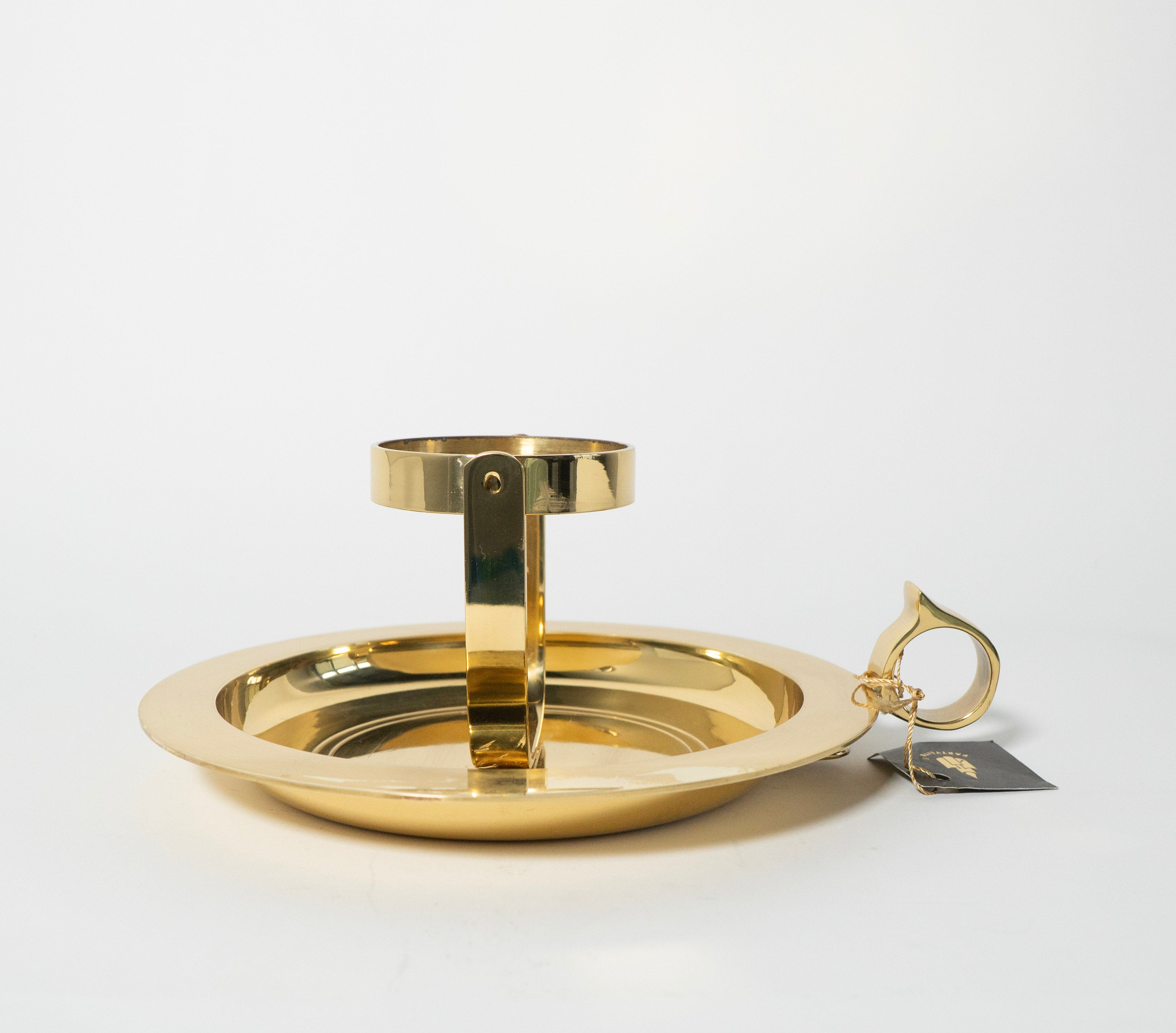 Gold candle holder with a tag on a white background