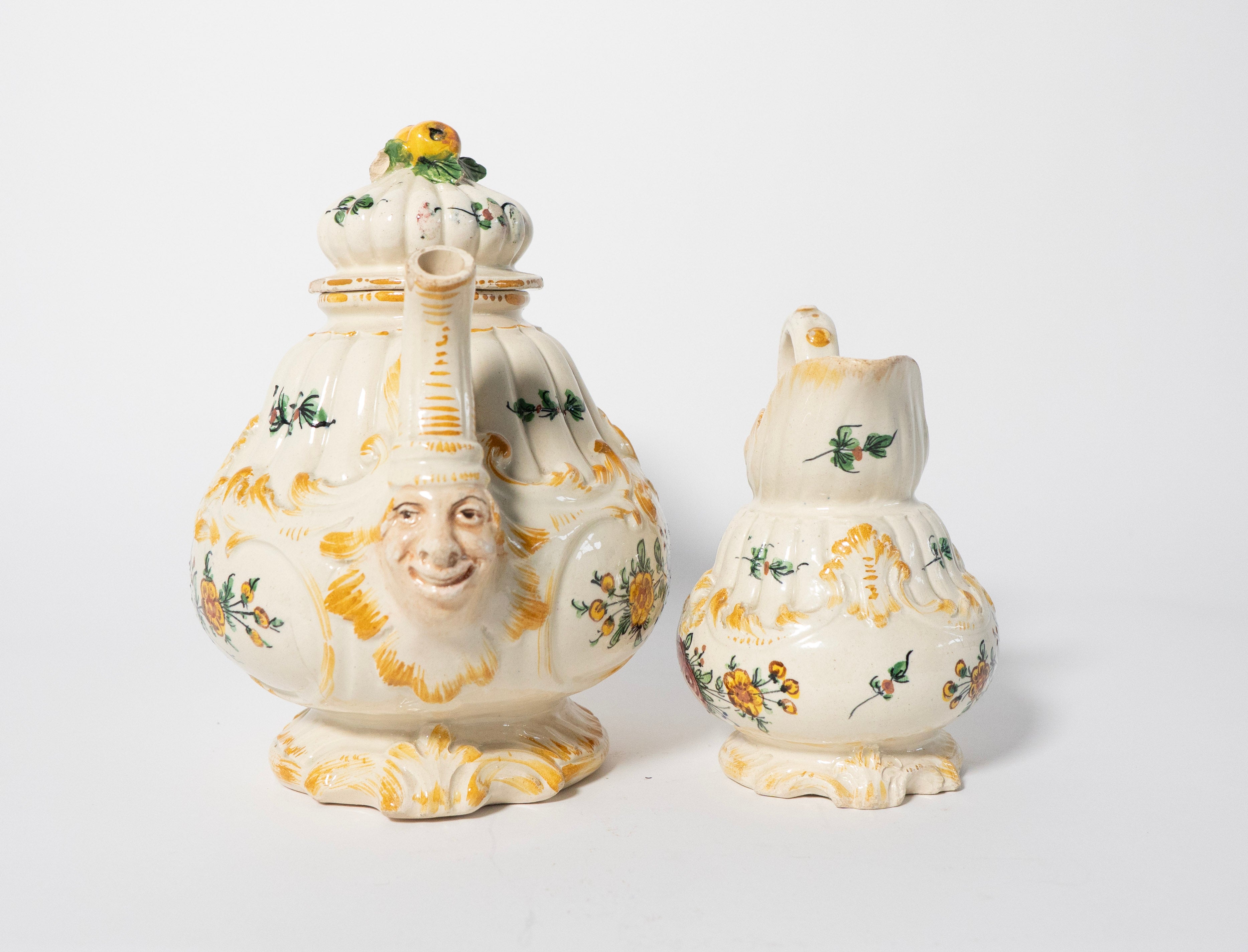Two ceramic jars with decorative faces and floral patterns on a white background