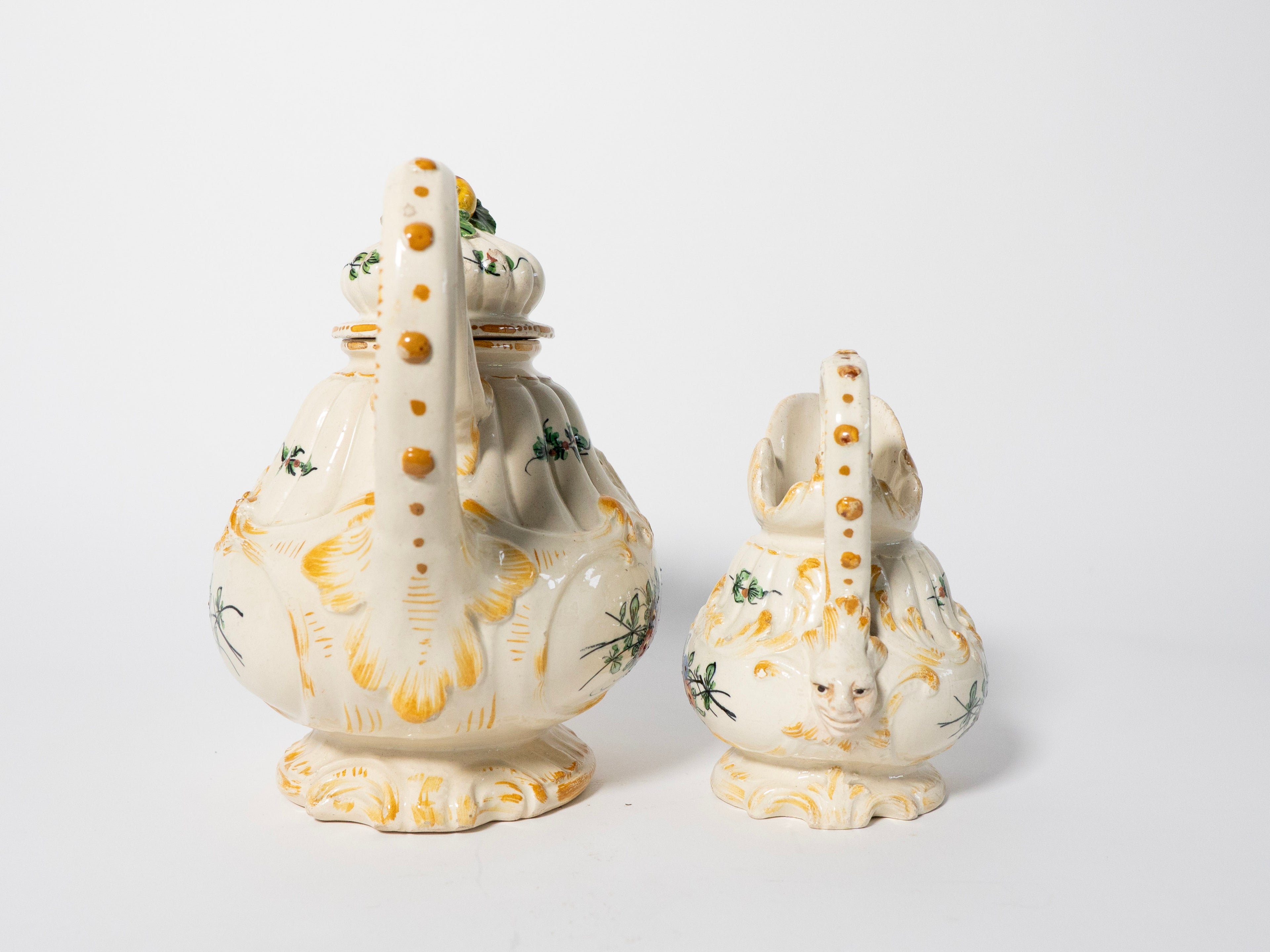 Decorative ceramic teapot and sugar bowl with floral patterns on a white background