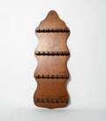 Wooden spoon rack with wavy design on a white background