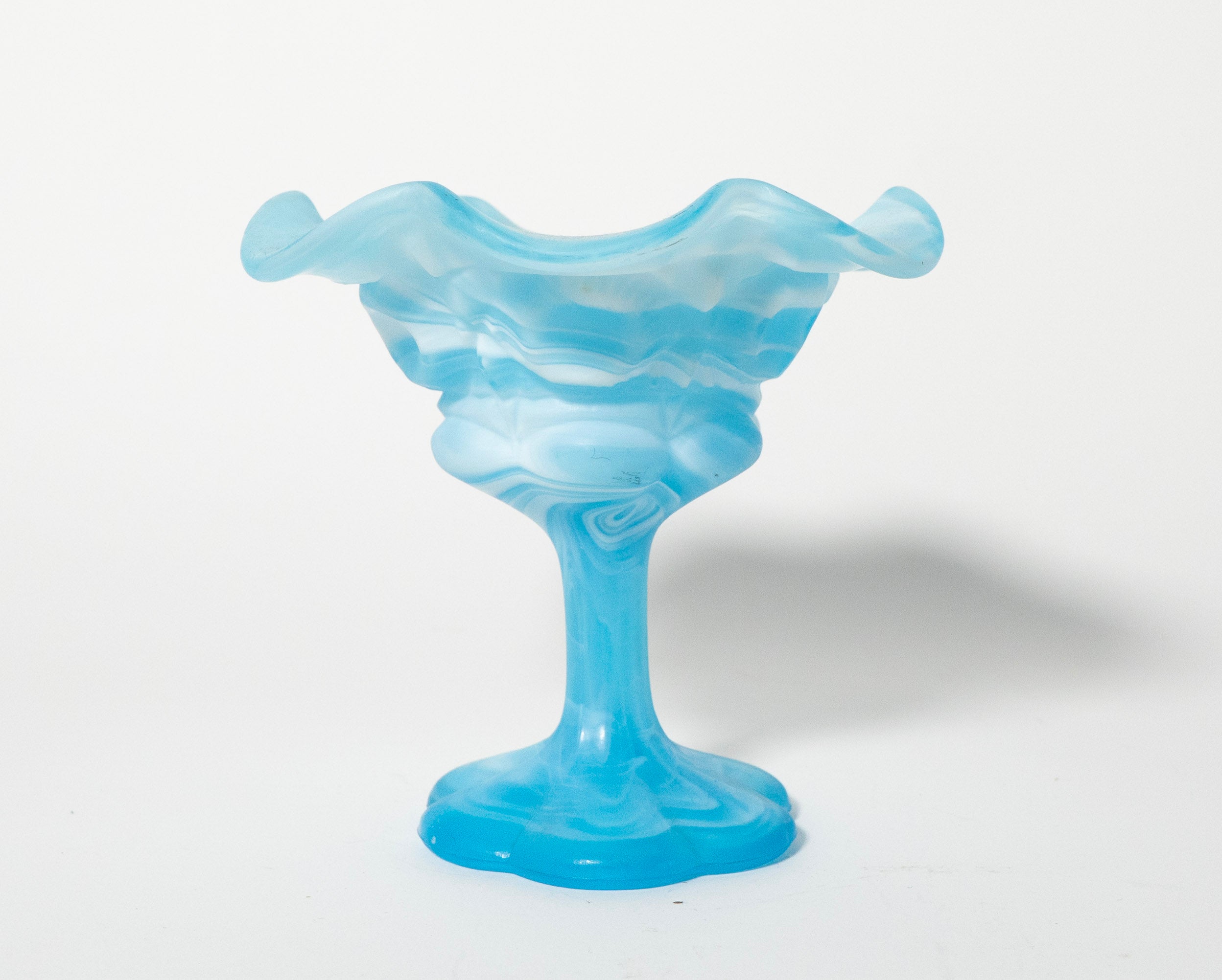 Blue glass vase with wavy design on a white background